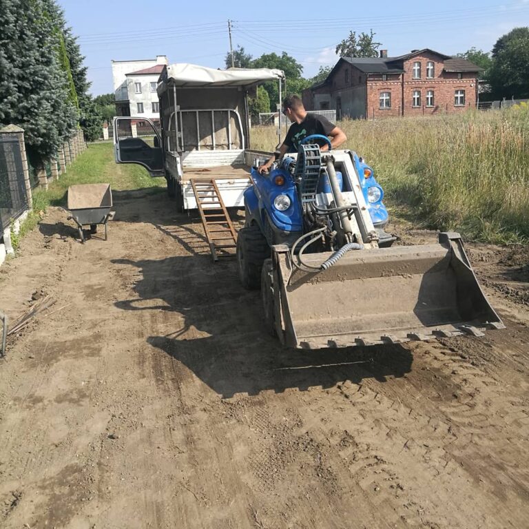 Mała koparka pomagająca w zakładaniu trawnika